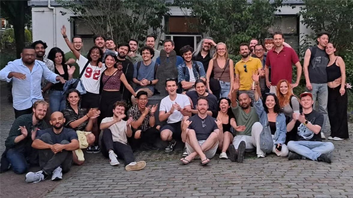 A big group of Utrechters on a cobbled square at dusk, grinning at the camera